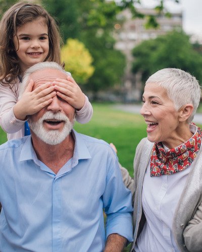 Grandparents playing a playful game with granddaughter, enjoying peace of mind from Final Expense Insurance in Hoover, Alabama.