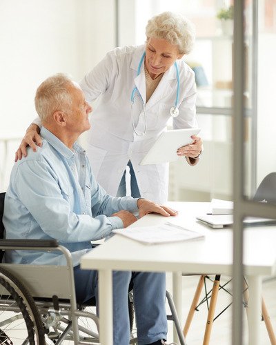 Doctor assisting older man in wheelchair, epitomizing the support of Medicare Supplement in Hoover, Alabama.